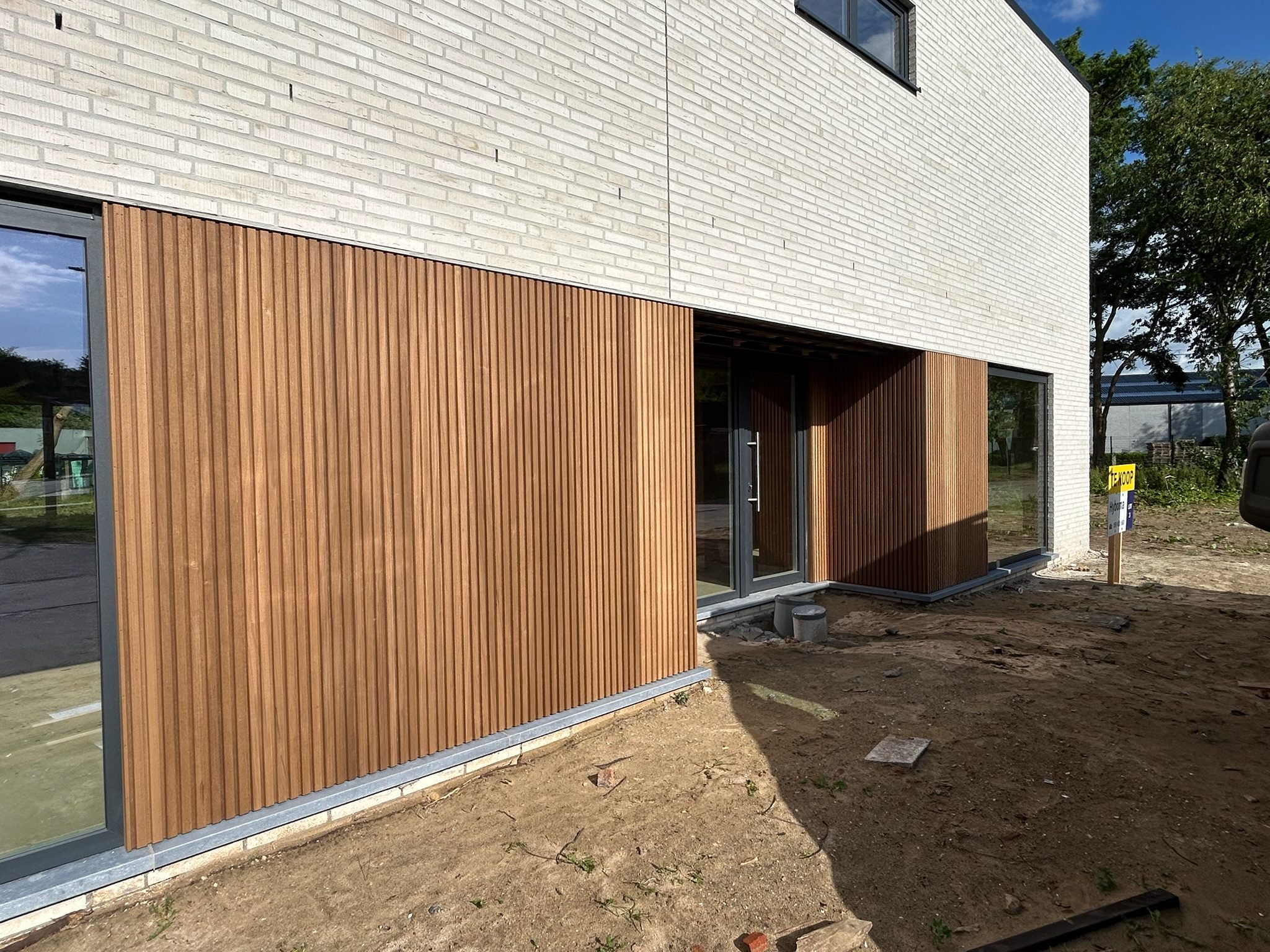 Houten gevelbekleding in verticale latten bij een nieuwbouw in Beernem