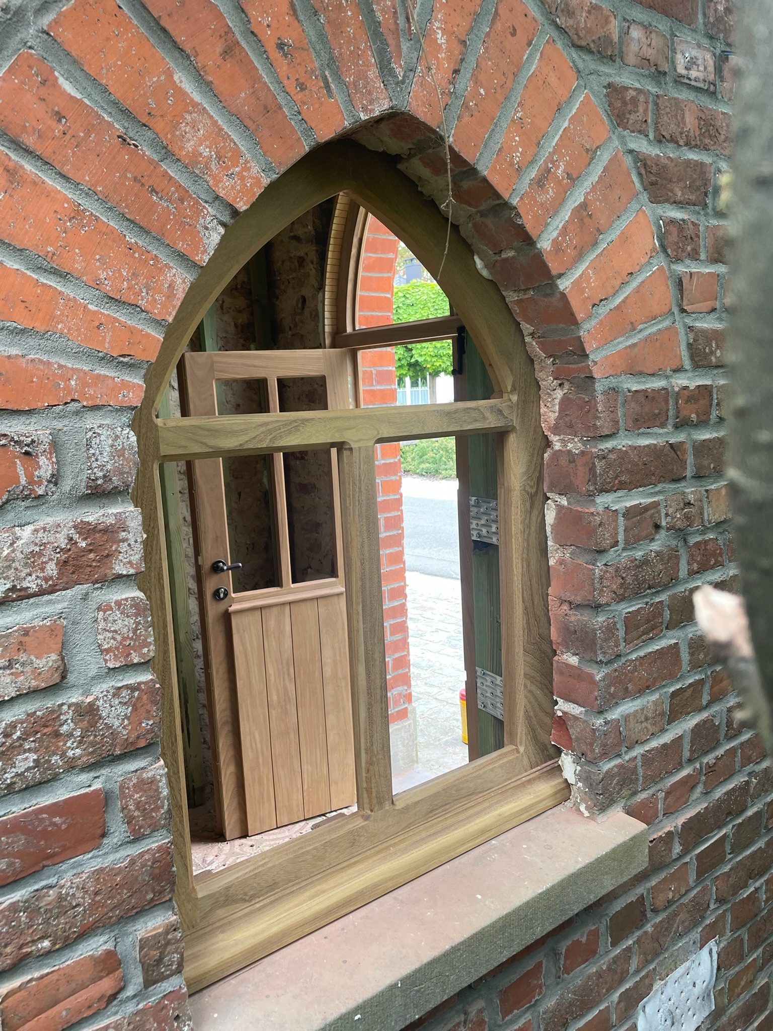 Houten raam op maat in een gotische spitsboog in Waregem
