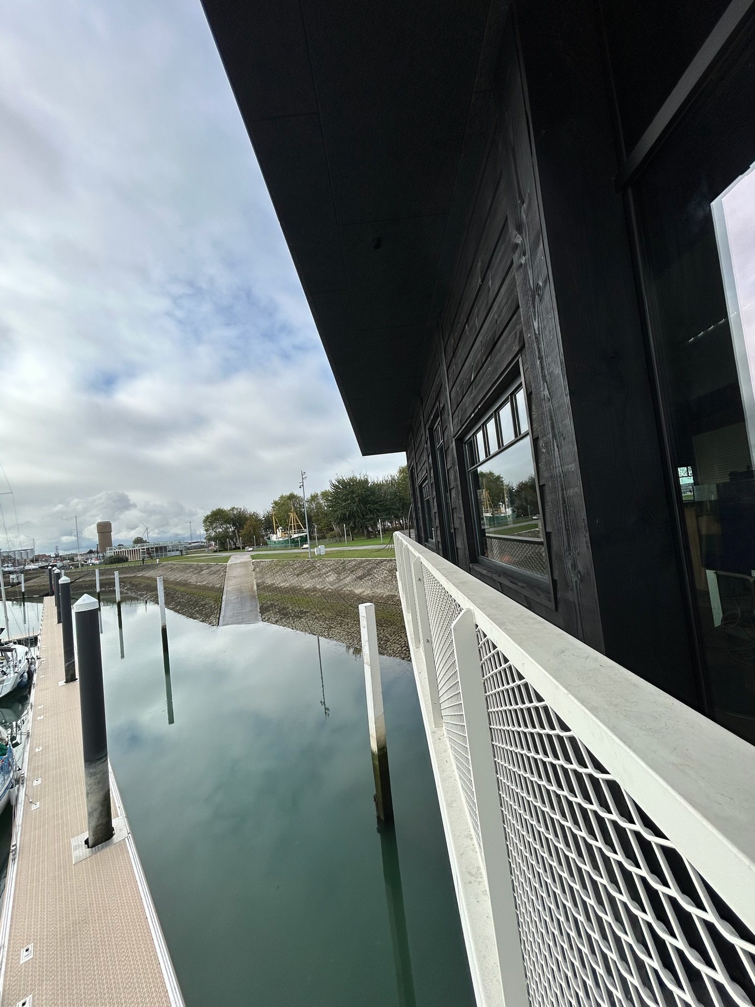 Zwarte houten gevelbekleding onder de dakoversteek van restaurant 't Werftje, boven de jachthaven van Zeebrugge