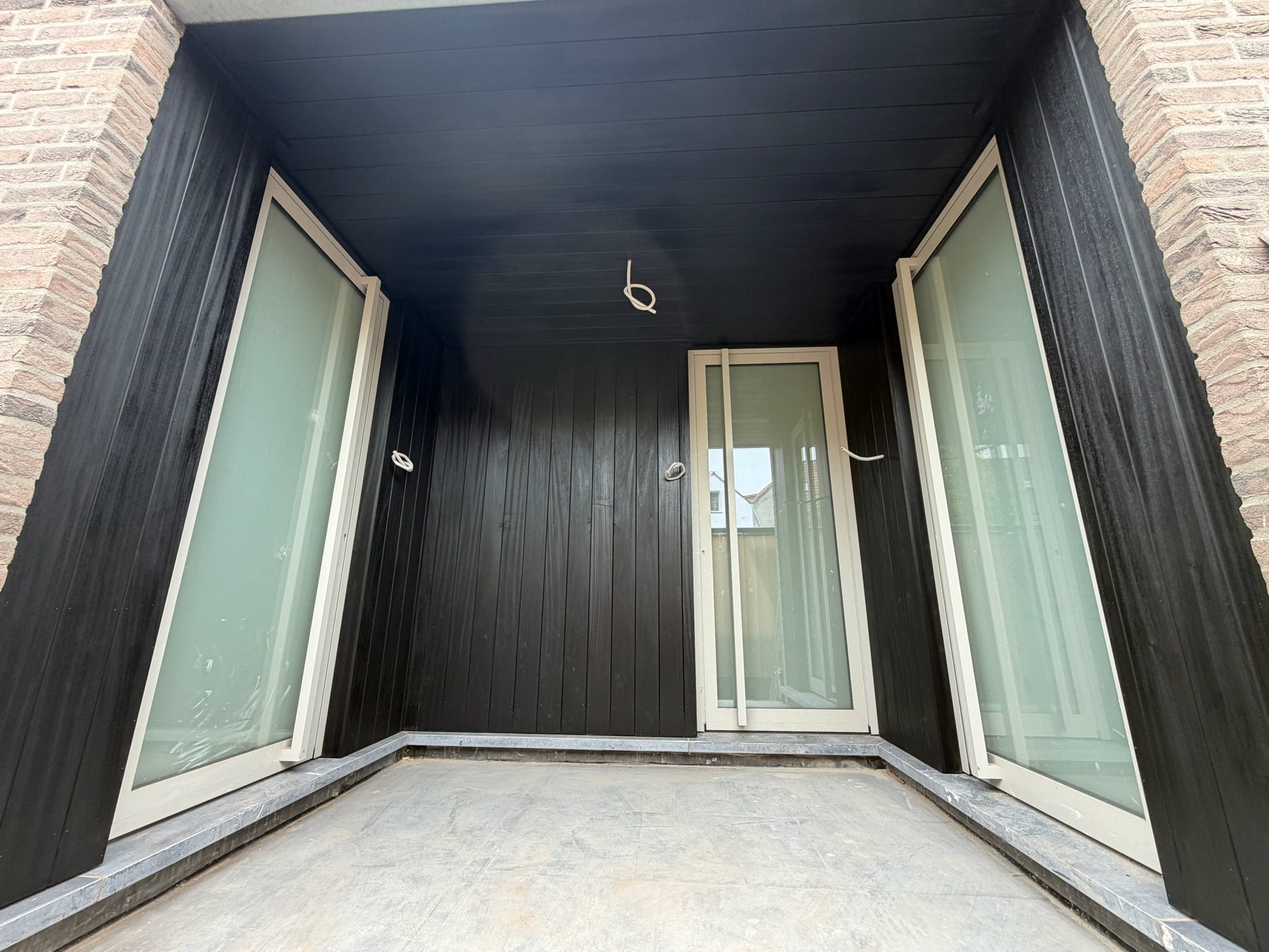 Loggia's bekleed met zwart hout rond glazen deuren in Brugge